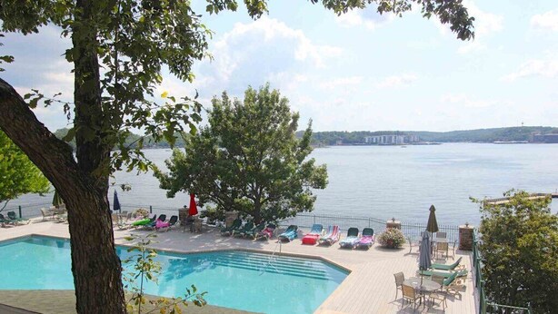 Ein Poolbereich mit Liegestühlen und Blick aufs Wasser.
