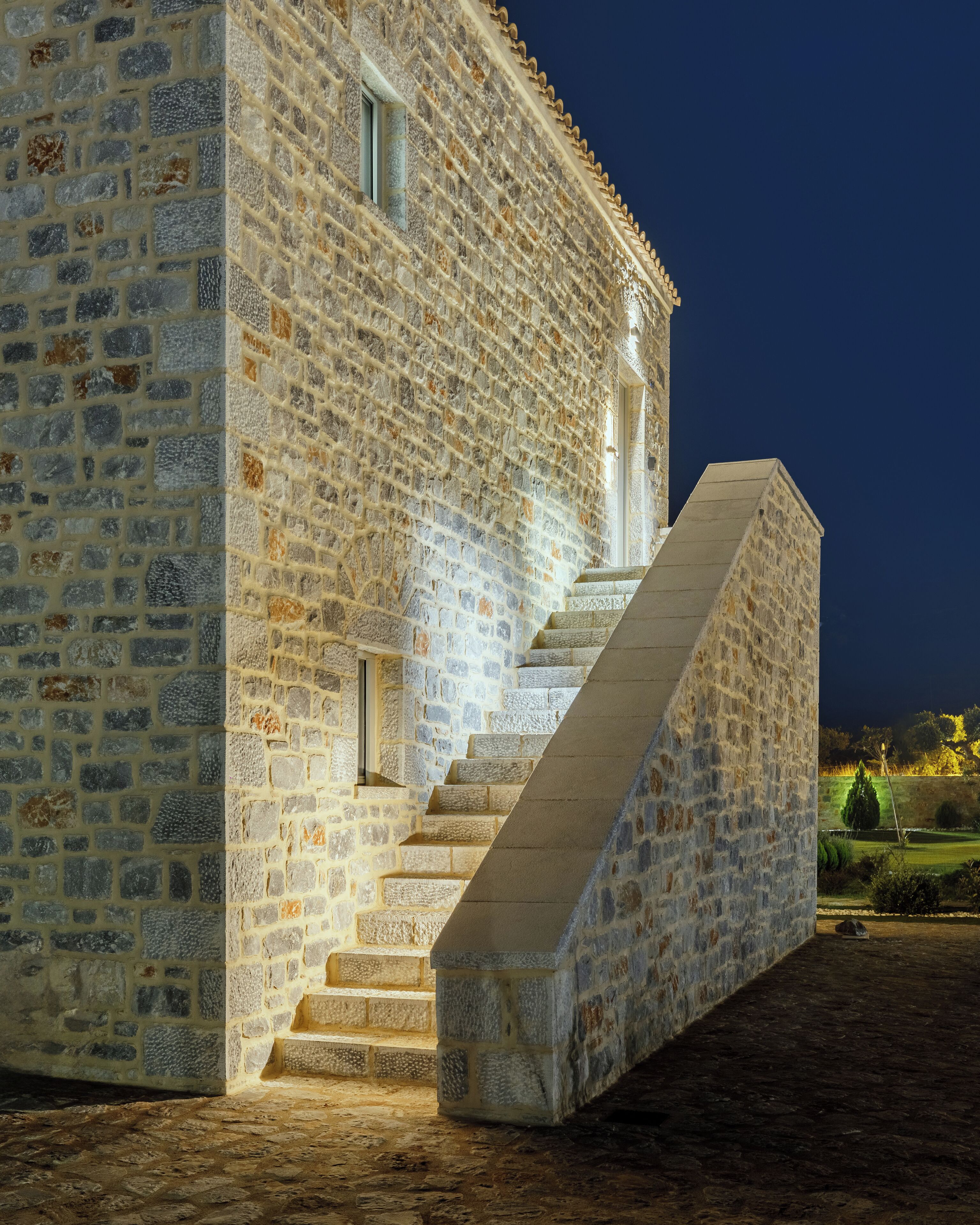 A stone building with a staircase leading to a door.