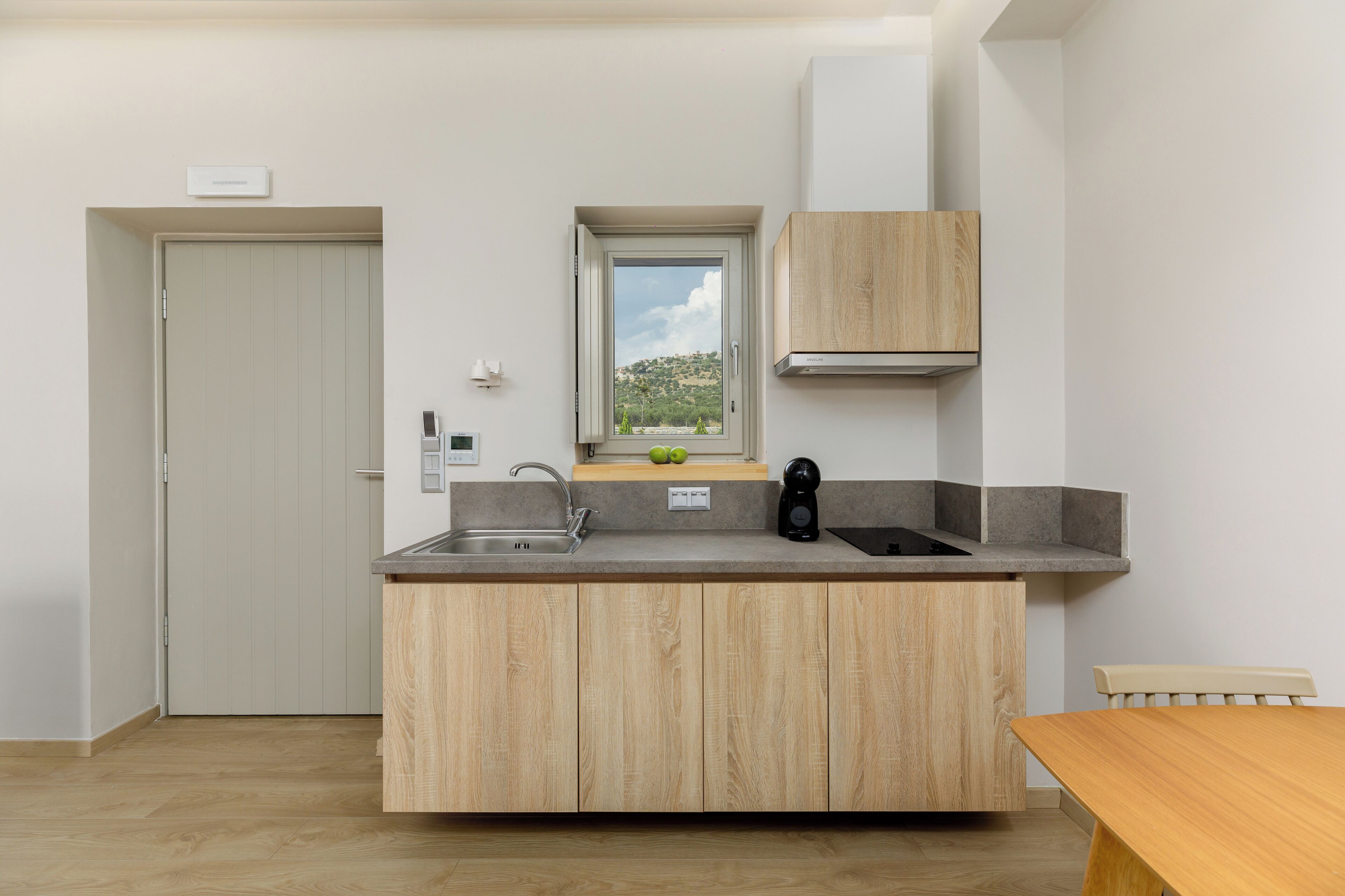 A modern kitchen with a built-in island, a window with a view, and wooden cabinetry.