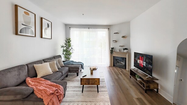 En stue med sofa, sofabord, pejs og fjernsyn.