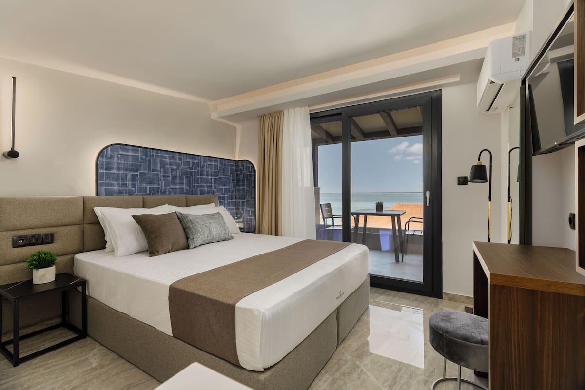 Suite estudio Deluxe, vistas al mar | Caja fuerte, mobiliario individual, escritorio y cortinas opacas