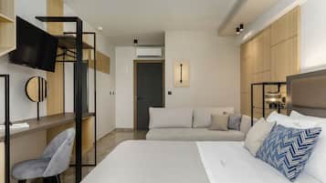 Una habitación de hotel moderna con una cama, un escritorio, una silla, un televisor y armarios empotrados de madera.