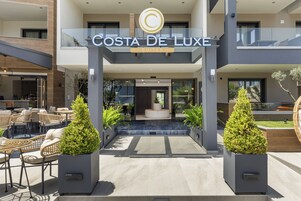 Un edificio moderno con un letrero que dice "Costa De Luxe Suites".