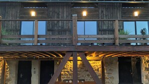 Ein Holzhaus mit Balkon und Steinmauer.