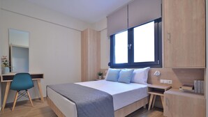Ein modernes Schlafzimmer mit Bett, Schreibtisch, Stuhl und Einbauschrank.