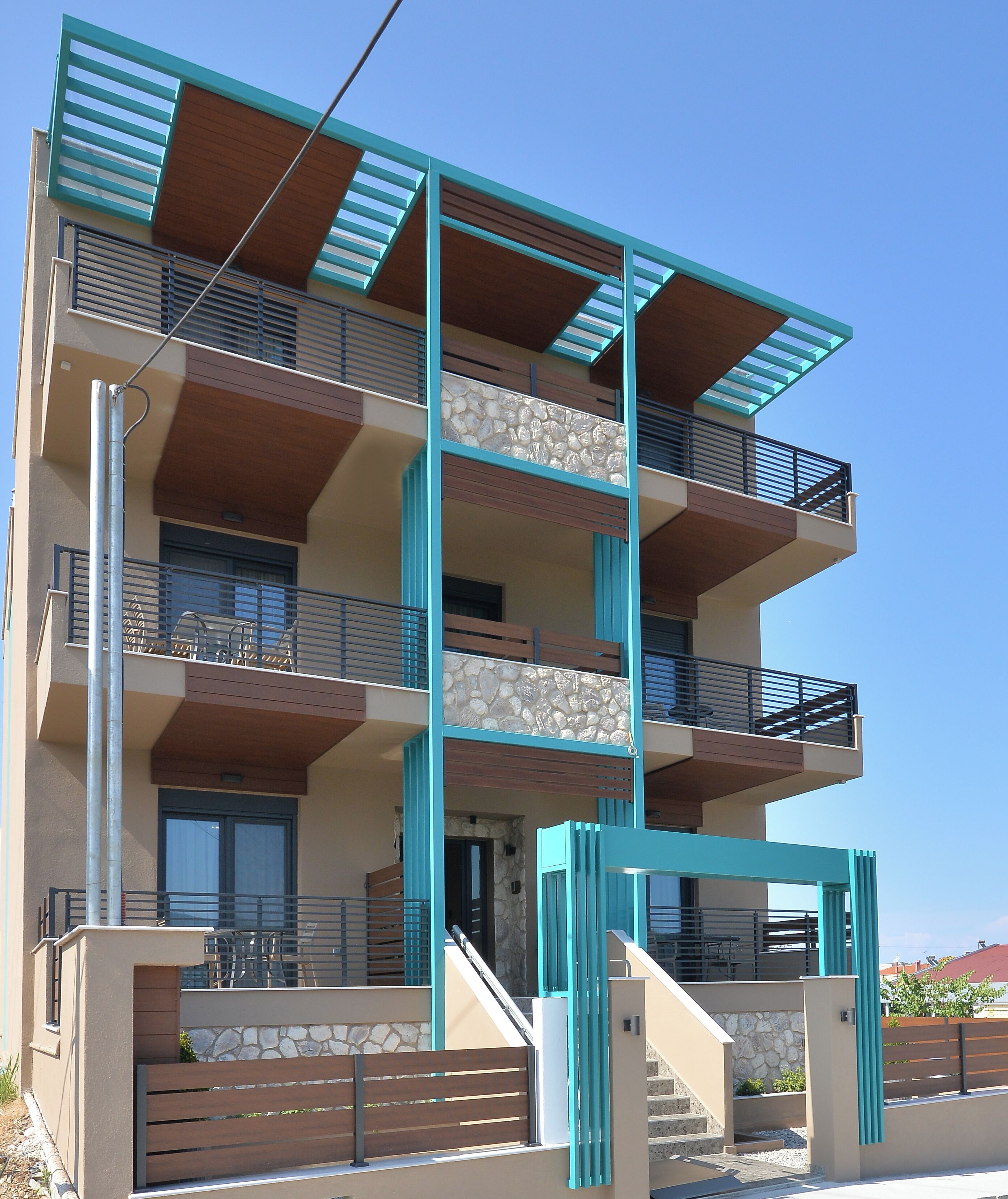 A multi-story building with balconies, a staircase, and a stone facade.