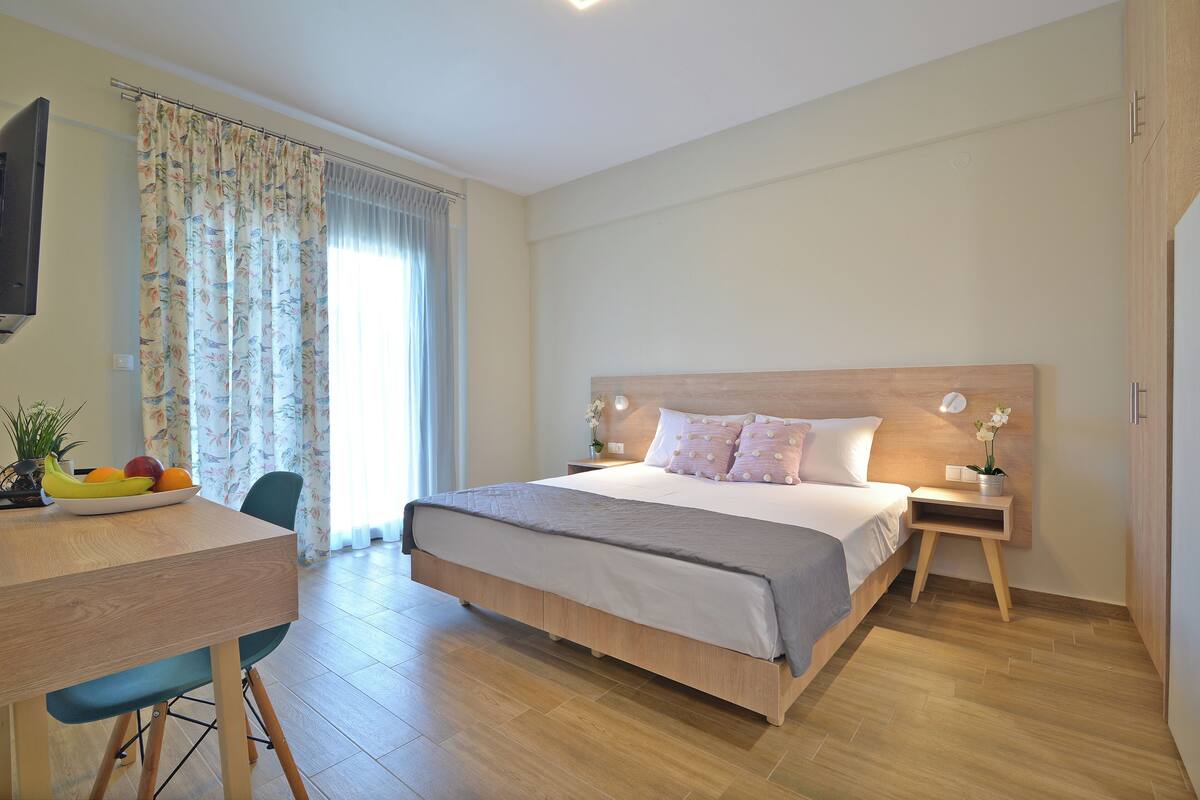 Un dormitorio con cama, mesita de noche y escritorio con silla.