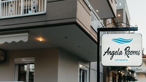 A sign for 'Angela Rooms' with a wave logo, indicating a beachfront or water-themed accommodation. - Angela Rooms (Dio-Olympos)