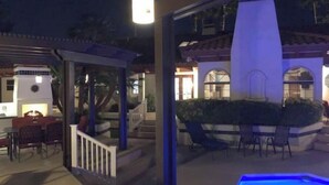 Eine Außenpatio-Terrasse mit Pool, Grill und Gartenmöbeln.