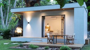 Uma casa moderna e minimalista com deck de madeira e área de refeições.