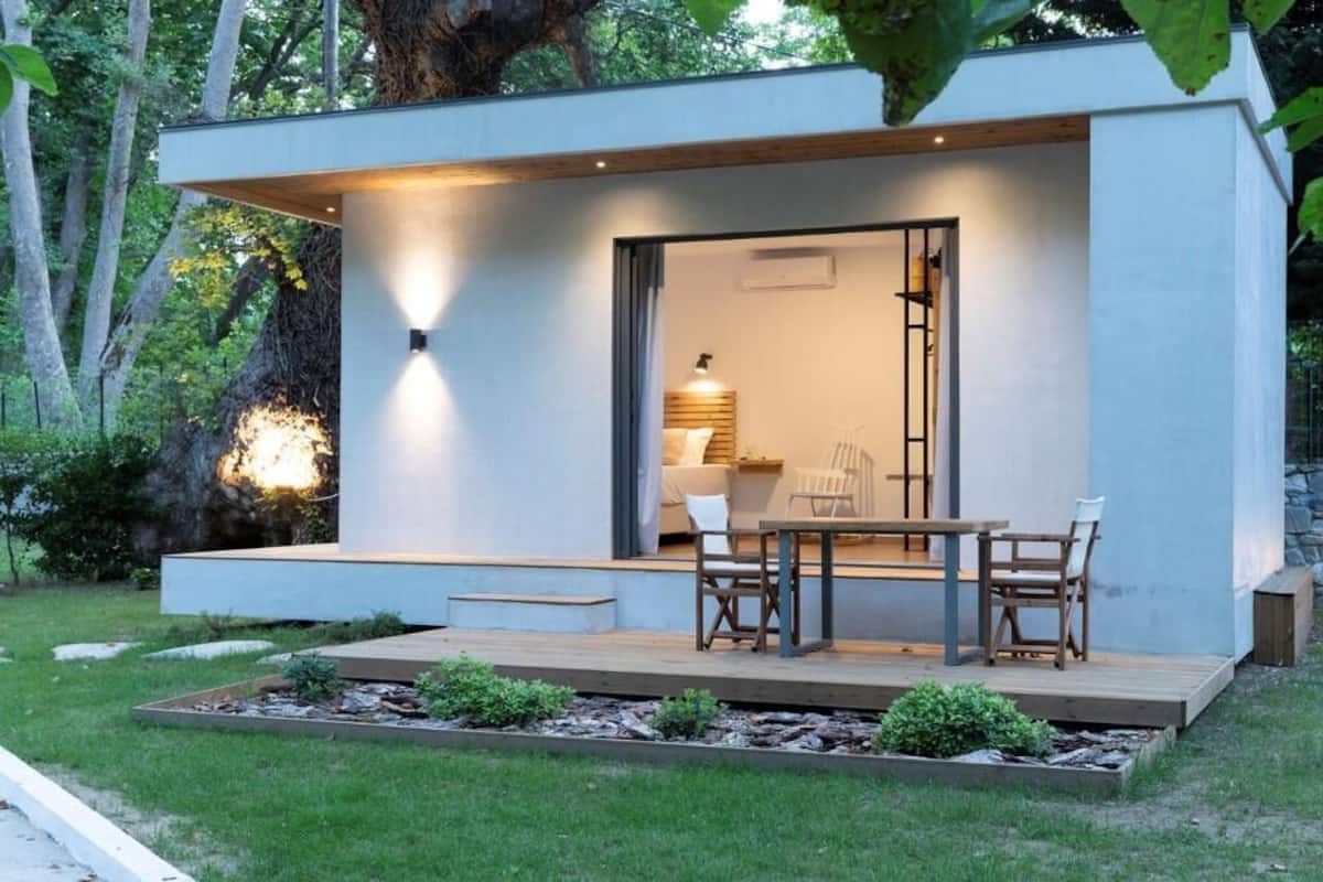 Ein modernes, minimalistisches Haus mit einer Holterrasse und einem Essbereich.