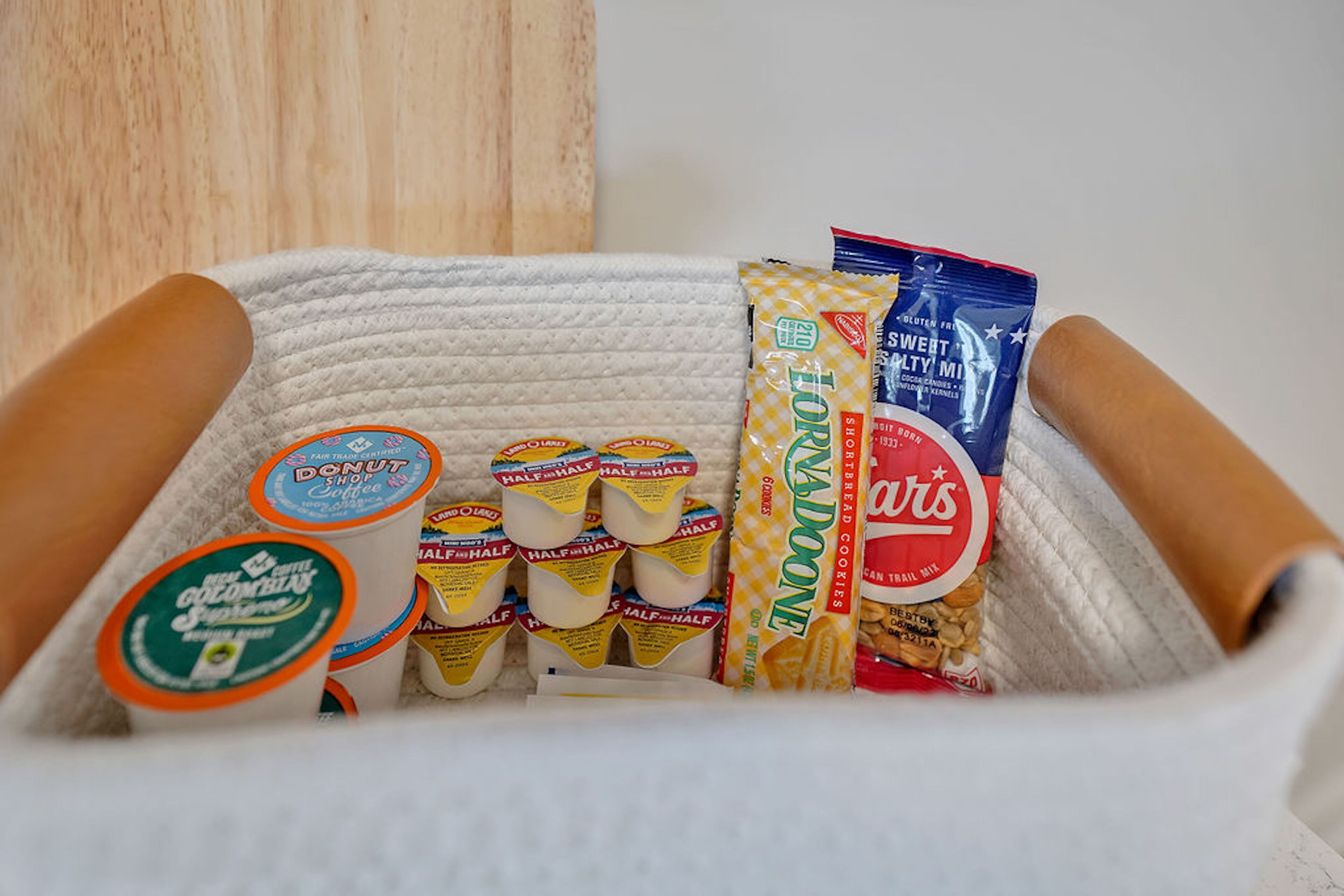 A basket containing various food items including yogurt, cookies, and a chocolate bar.