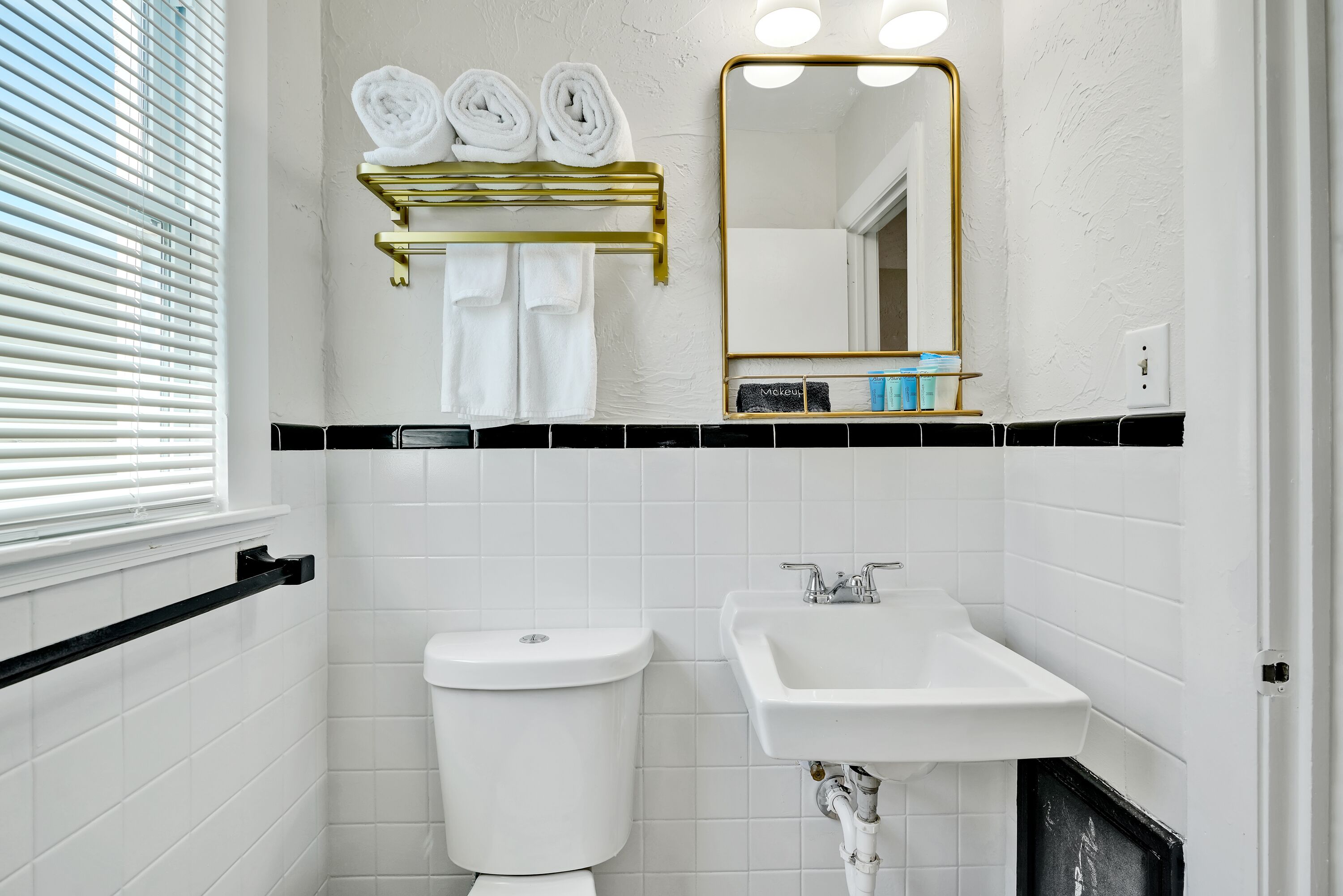A bathroom with a toilet, sink, and towel rack.