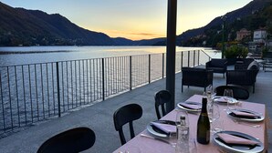 Une table dressée pour le dîner, avec vue sur un lac et des montagnes.
