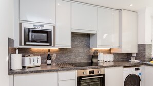 Een moderne keuken met een ingebouwde magnetron, broodrooster en oven.
