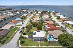Una zona residencial costera con casas, un puerto deportivo y una vista despejada del océano.