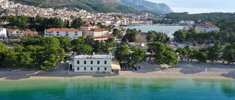 A coastal town with buildings, a beach, and a body of water.