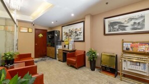 Een hotel lobby met een receptiebalie, een zithoek en een groot kunstwerk in een lijst aan de muur.