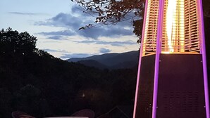 A table set for a meal outdoors with glasses of wine and a candle. - Cozy Cabin in Nantahala Village (Bryson City)