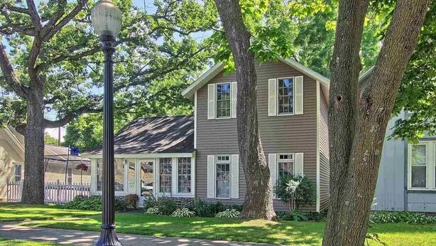 A two-story house with a front porch, a street lamp, and a well-maintained lawn. - TC TWO OAKS Home / Minutes walk to Downtown & Beach (Traverse City)