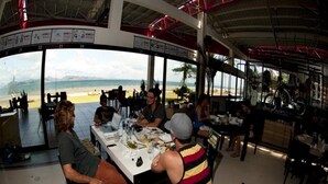 A restaurant with a view of the beach, tables set for dining, and a casual atmosphere. - Nitro City Panama Action Sports Resort (Punta Chame)