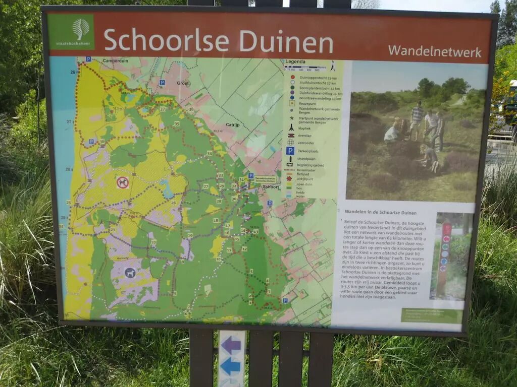 Eine Karte der Schoorse Duinen mit Legende und einem Foto von Wandernden.