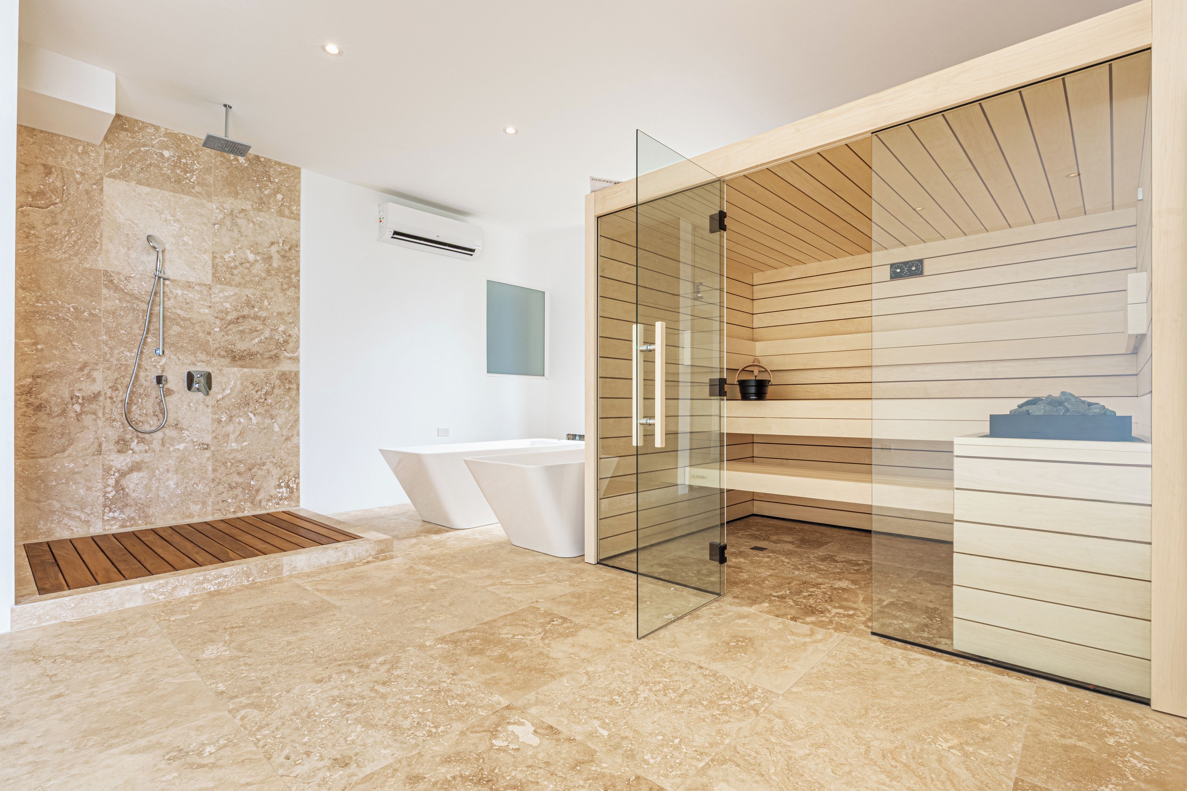 Ein modernes Badezimmer mit Dusche, Badewanne und einem in Glas eingefassten Waschtisch.