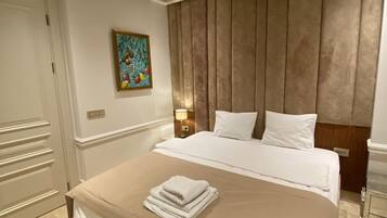 Una habitación de hotel con una cama grande, un cuadro en la pared y un techo con diseño de cuadrícula.