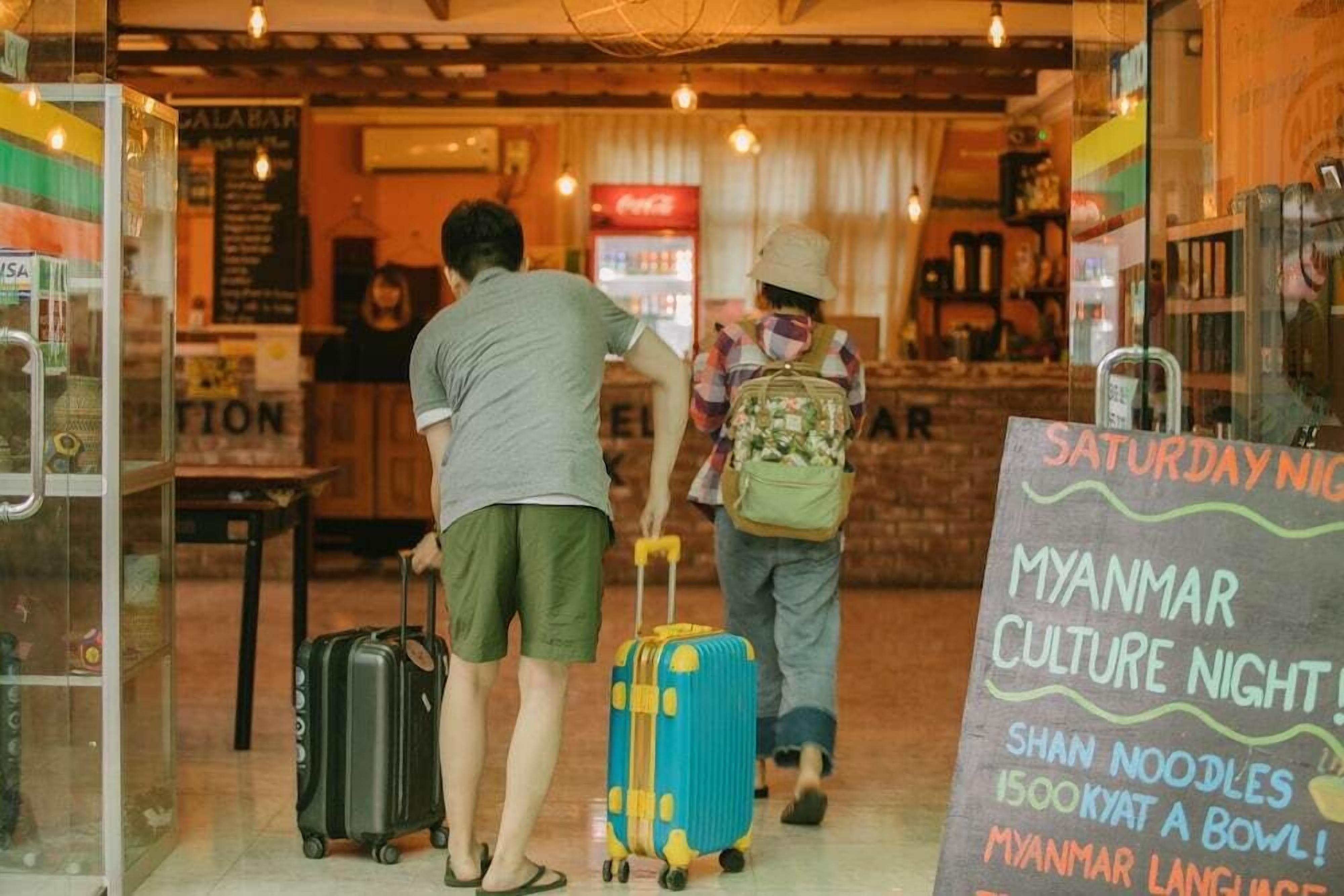 Un interior acogedor con un cartel que anuncia 'Noche Cultural de Myanmar del Sábado' con fideos Shan y un bol.