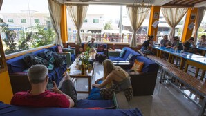 A spacious lounge area with sofas and benches, large windows, and a view of the outside. - Ostello Bello Nyaung Shwe (Nyaungshwe)