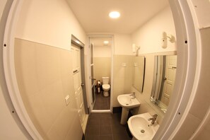 A compact bathroom with a toilet, sink, and mirror. - Ostello Bello Nyaung Shwe (Nyaungshwe)