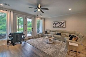 A modern living room with a sofa, coffee table, and a desk with chairs. - Lakefront Retreat in Lake Hamilton (Lake Hamilton)