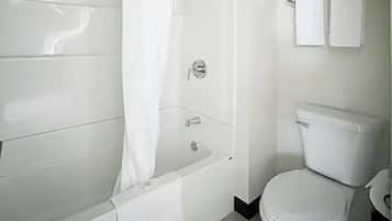 A bathroom with a bathtub, toilet, and a shower curtain.
