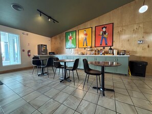 A restaurant with a counter, chairs, and a tiled floor.