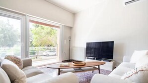 Un salon moderne avec un canapé, une table basse et un téléviseur.