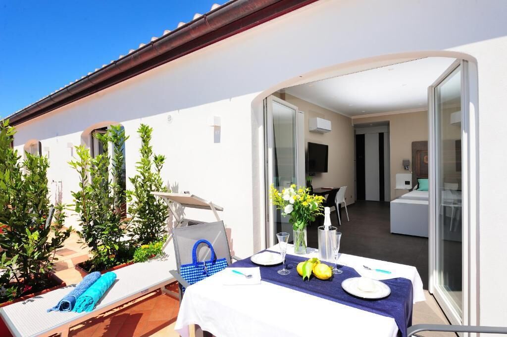 A balcony with a table set for two, a chair, and a blue towel.