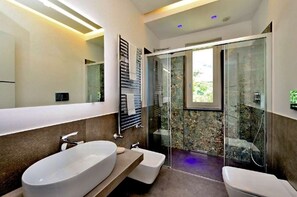 A modern bathroom with a large oval sink, a bidet, and a glass-enclosed shower. - Amalfi Blu Retreat  (Amalfi)