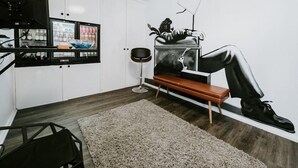 A modern kitchen with white cabinets, a refrigerator, a black countertop, and a mural of a person sitting on a bench. - Soya Apartment Hotel (Melbourne)