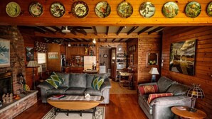 L’intérieur chaleureux d’un chalet comprend un salon avec deux canapés, une cheminée et un coin repas.