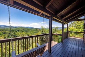 A wooden deck with a view of a forested mountain range. - Loft - Fireplace, Firepit, Pickle Ball, Hot Tub (Sevierville)
