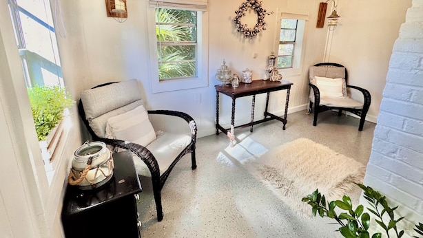 Une pièce chaleureuse avec deux fauteuils, une petite table et une couronne décorative accrochée au mur.