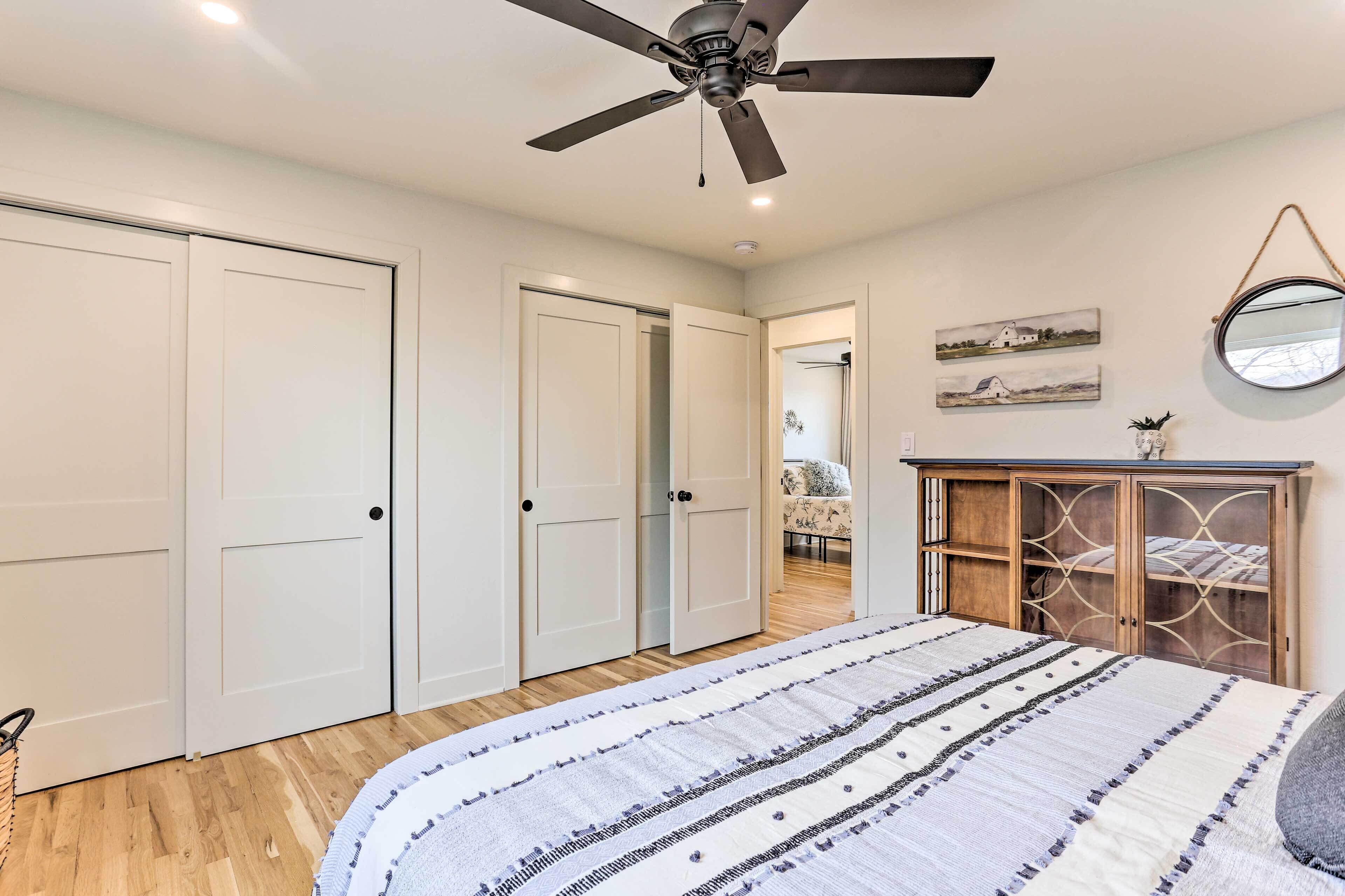 A bedroom with a bed, a ceiling fan, and a wardrobe.