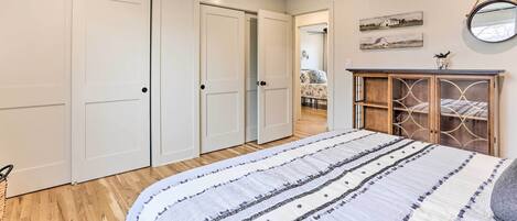 A bedroom with a bed, a ceiling fan, and a wardrobe.