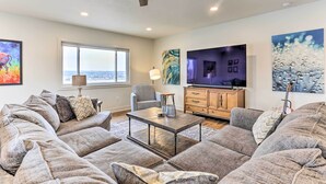 A modern living room with a sectional sofa, a coffee table, a TV, and artwork on the walls. - 2 Mi to Dtwn Castle Rock: Home w/ Furnished Patio (Castle Rock)