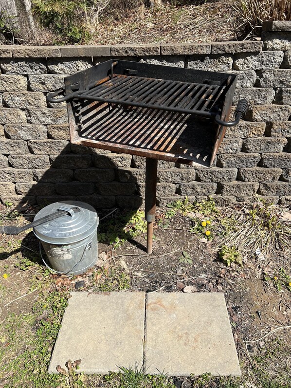A barbecue grill with a metal pot and a stone slab in front of a stone wall. - Loaded with fun! Hot Tub, Huge Porch, Pool table, Arcade, Starlink, & Outdoor TV (Sevierville)