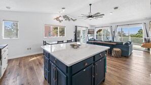 A spacious kitchen with a large island, wooden flooring, and a ceiling fan. - Steps to Fenwick Island Beach, Ocean&Bay views, hot tub. Pet & family friendly! (Fenwick Island)