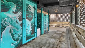 A wooden deck with a mural of a wave and a mermaid, a wooden bench, and a lattice fence. - Steps to Fenwick Island Beach, Ocean&Bay views, hot tub. Pet & family friendly! (Fenwick Island)