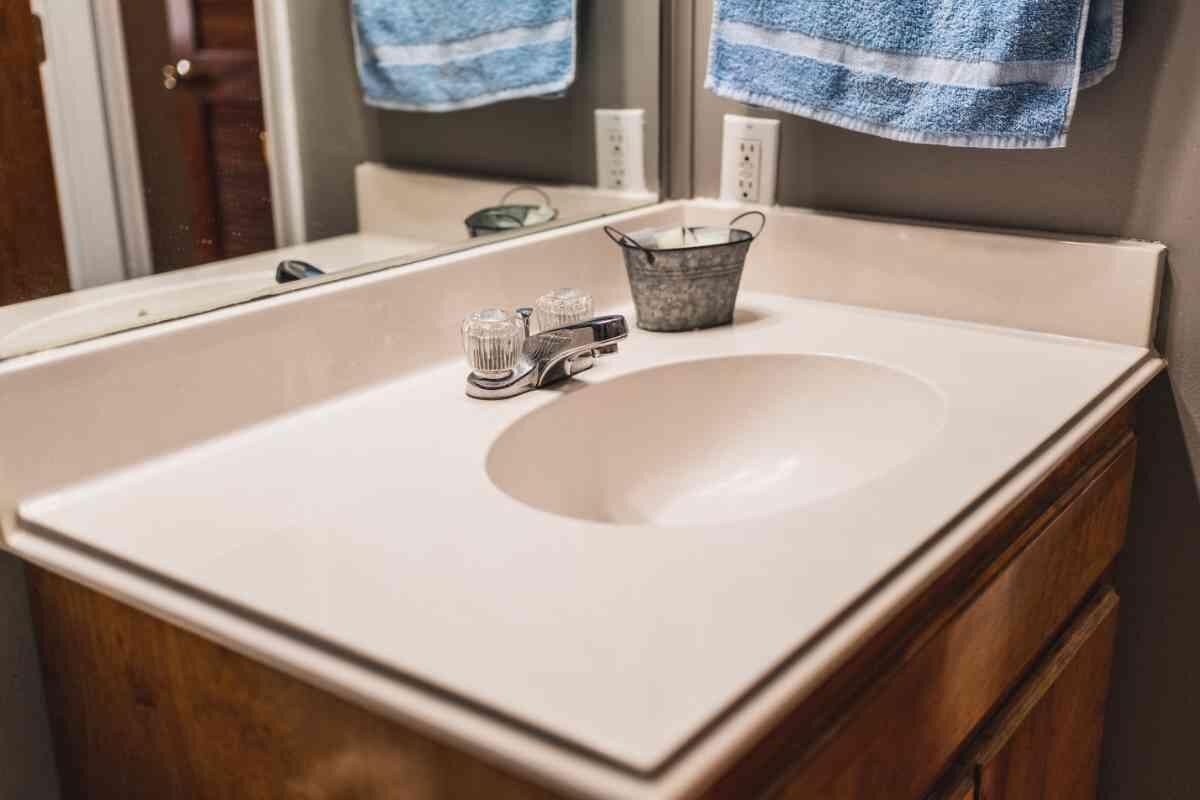 A bathroom with a white sink, a mirror, and a wooden cabinet.
