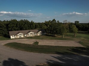 A large house with a driveway and a lawn.