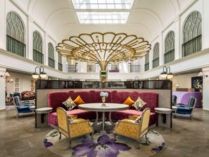 A spacious lobby with a central seating area, a high ceiling with a decorative light fixture, and large windows. - Mercure Dalat Resort (Lam Vien - Da Lat)